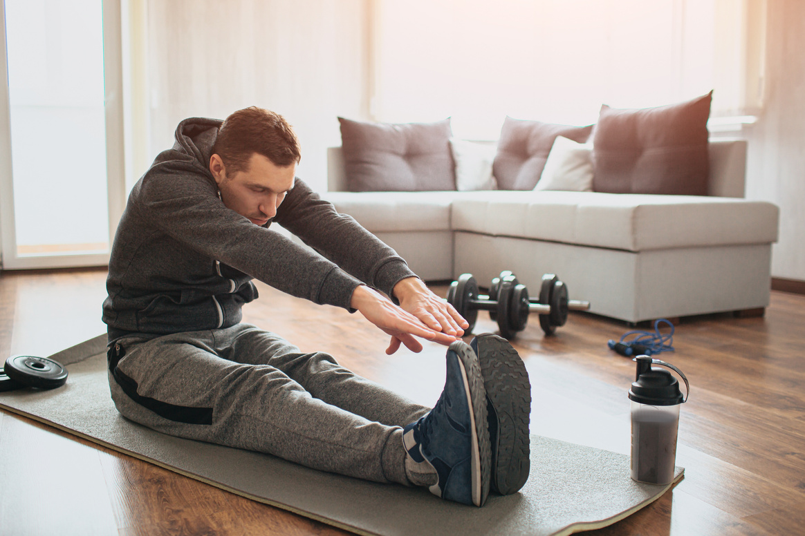 Young ordinary man go in for sport at home. Beginner or amat